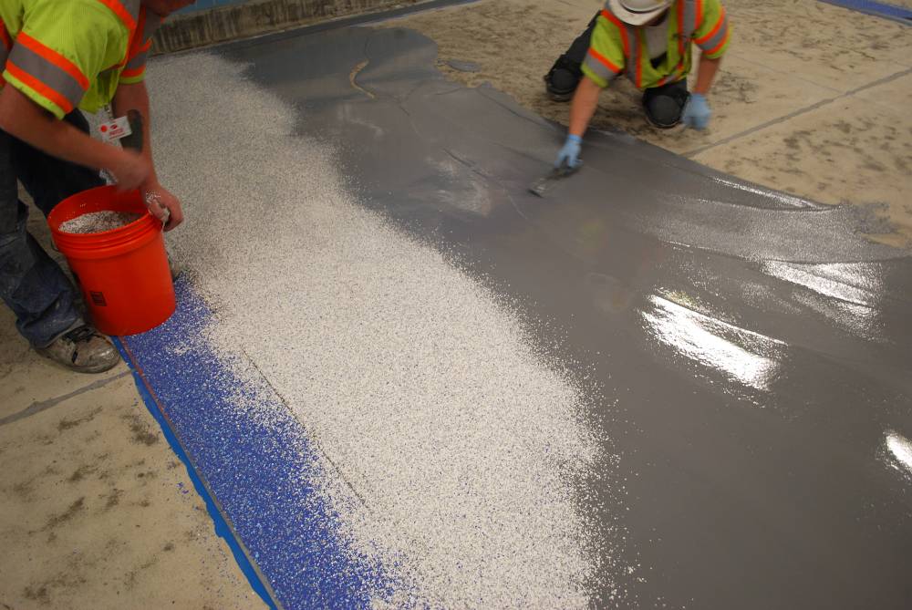 Decorative vinyl chips are broadcast into the epoxy coating.