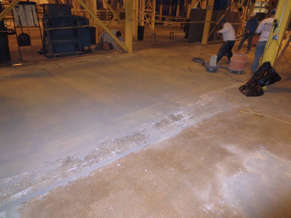 Here the excess slip-resistant aggregate is being removed. Note the dried spalling repairs.